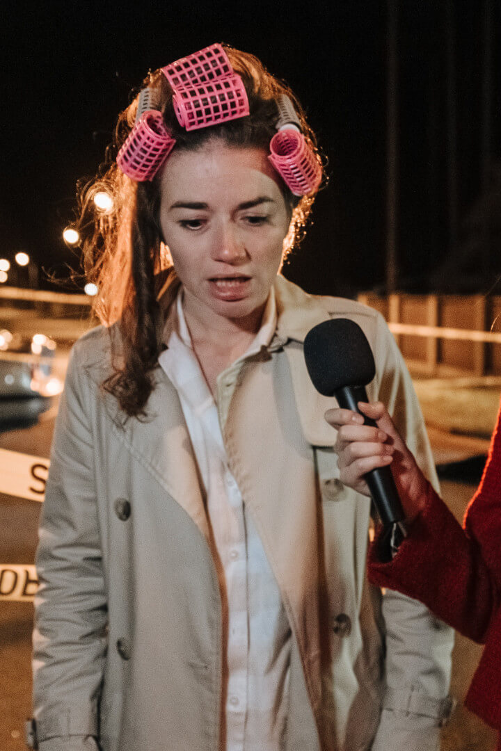 Disheveled woman answering a reporter's questions on camera.
